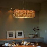 Hanging light over the table and recessed lighting over a counter in the back